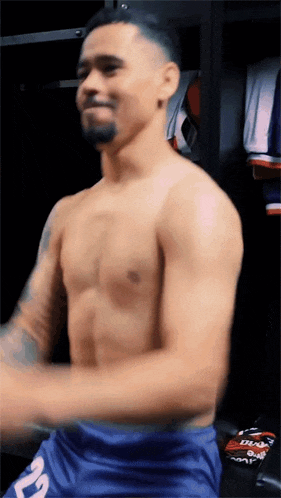 a shirtless man with the number 22 on his shorts is dancing