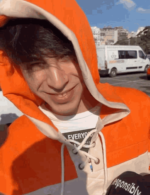 a young man wearing an orange hoodie with the word responsible on the back