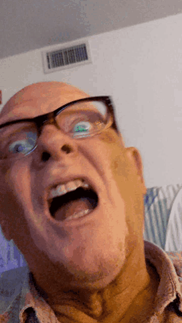 a man wearing glasses is making a funny face with his mouth open