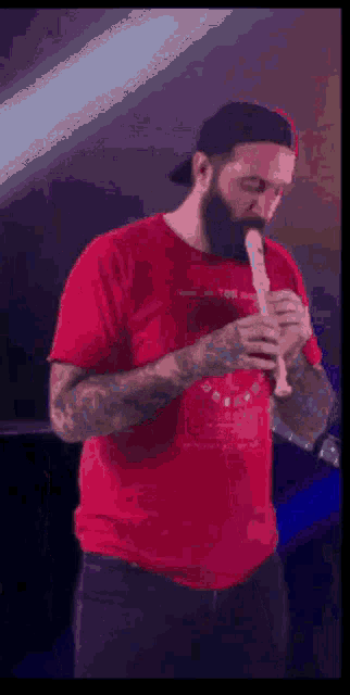 a man in a red shirt playing a recorder