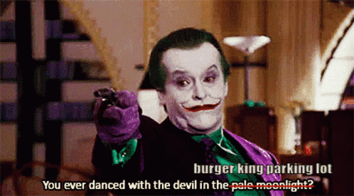 a man in a joker costume is holding a gun and says " burger king parking lot "