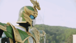 a man in a green and gold robot costume with a dragon on his head .