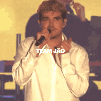 a man singing into a microphone with the word team jao on the bottom right