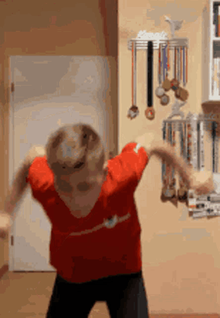 a young boy in a red nike shirt is dancing