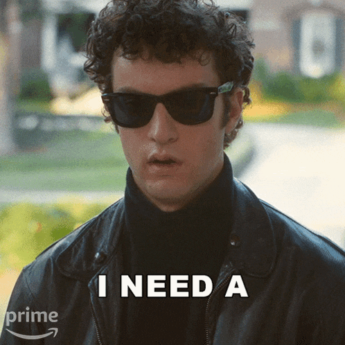 a man wearing sunglasses and a black leather jacket says i need a