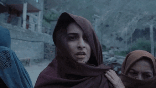 a woman wearing a scarf around her head looks very angry