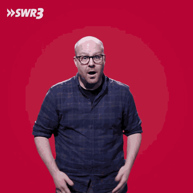 a man in a blue plaid shirt is making a funny face with swr3 in the background