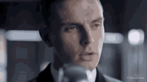 a man in a suit and tie is looking at a camera .