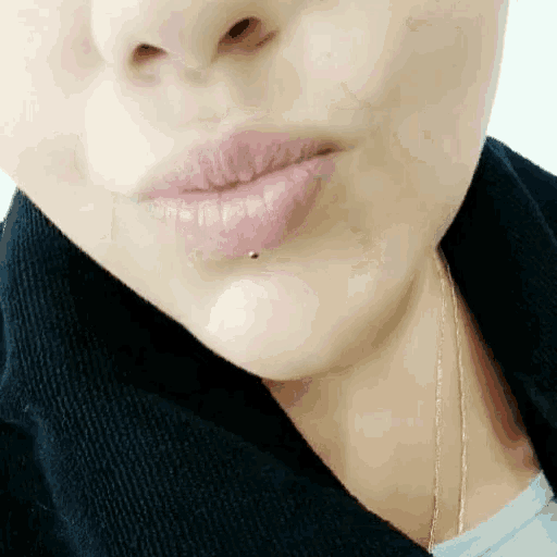 a close up of a woman 's lips with a lip piercing