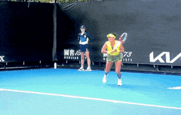 a woman is playing tennis on a court with a ktm sign in the background