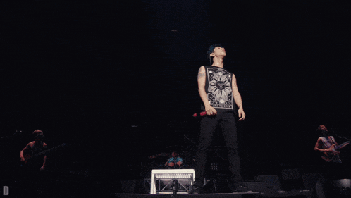 a man singing into a microphone while wearing a shirt that says " i am a king "