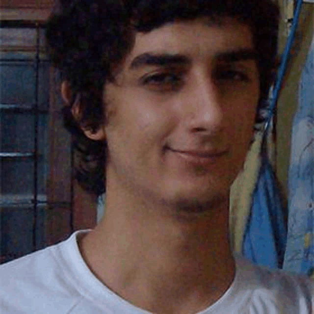 a young man with curly hair wearing a white shirt