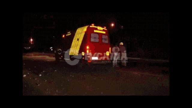 an ambulance is parked on the side of the road at night .