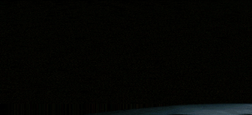 a blurred image of a crowd of people sitting in a dark room