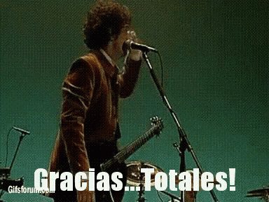a man singing into a microphone while holding a guitar with the words gracias totales written below him