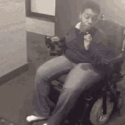 a man in a wheelchair is smoking a cigarette while holding a microphone .