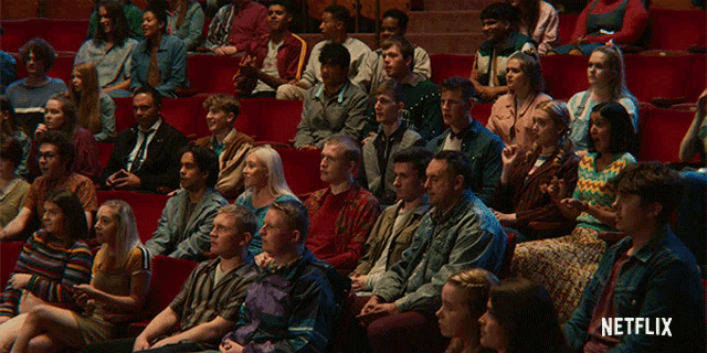 a large group of people are sitting in an auditorium with a netflix logo on the bottom