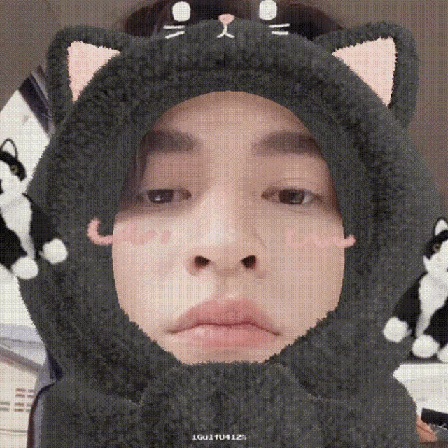 a man is wearing a cat hat with ears and a scarf around his head .