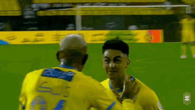 two soccer players are hugging on the field and one has the number 7 on his shirt