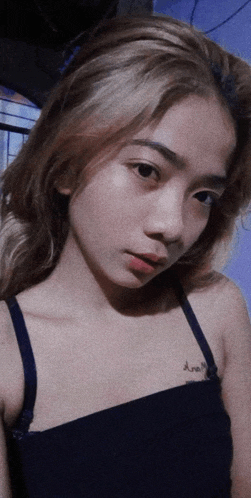 a girl with a tattoo on her shoulder that says ' ariel '