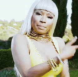 a woman wearing a yellow dress and a gold choker is pointing at the camera .