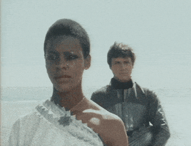 a man and a woman standing on a beach