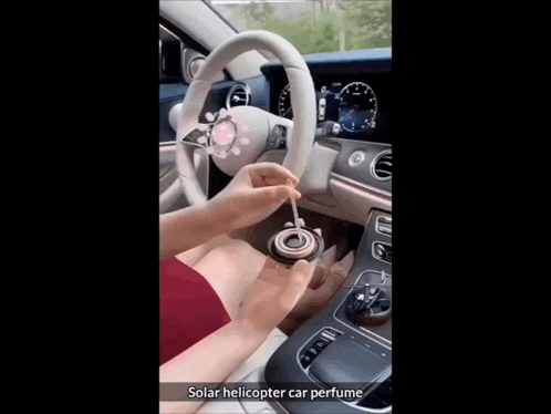 a woman sitting in a car with a solar helicopter car perfume