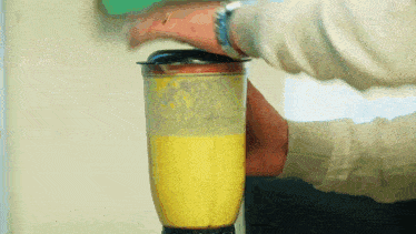 a blender is being used to make a yellow liquid
