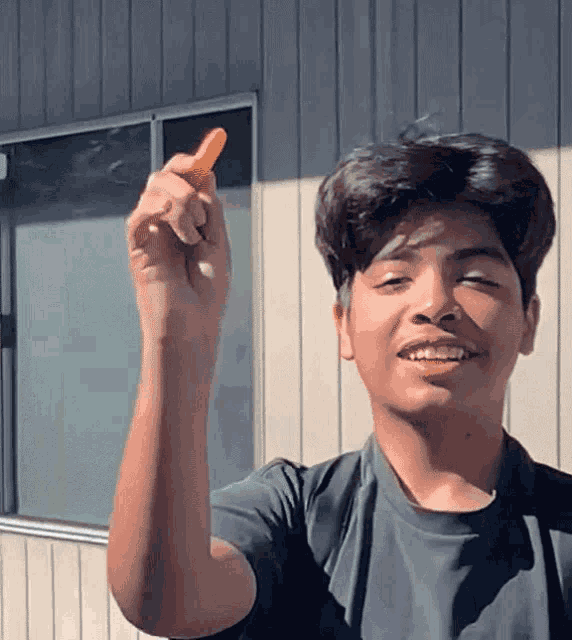 a young man is holding a carrot in his hand
