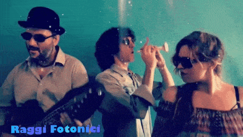 a man playing a guitar and a woman blowing soap bubbles with the words raggi fotonici behind them
