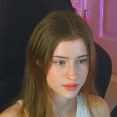 a close up of a woman 's face with long hair sitting in a chair .