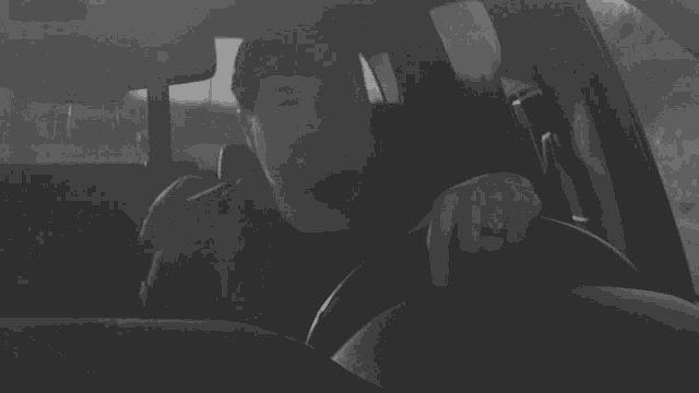 a man wearing a ring is sitting in a car