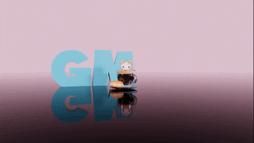 a cup of coffee with a cat on top sits on a table with the letters gm behind it