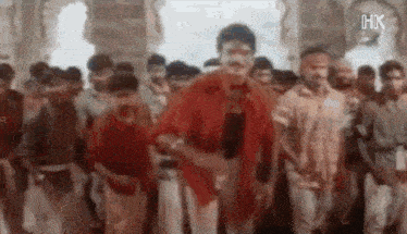 a man is dancing in front of a crowd of people .
