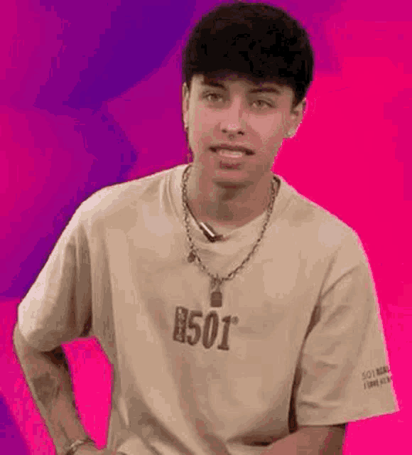 a young man is wearing a t-shirt and a necklace .