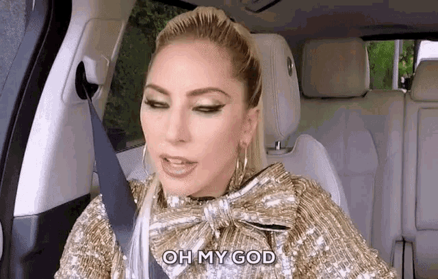 lady gaga is sitting in the back seat of a car wearing a bow tie and a seat belt .