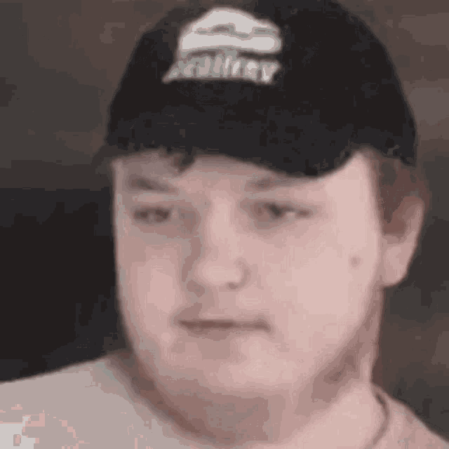 a close up of a man wearing a hat and a white shirt .