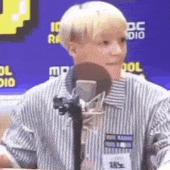 a young man is sitting in front of a microphone in a radio station .
