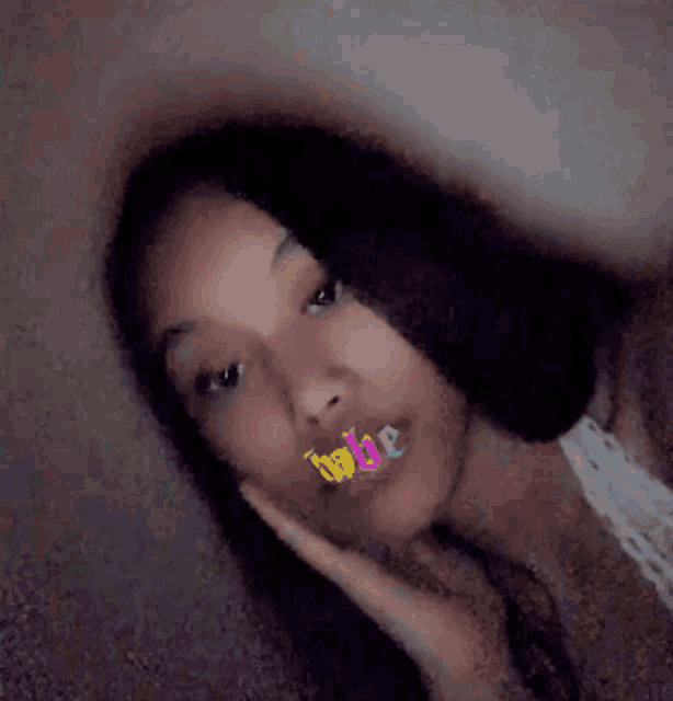 a girl with long hair is taking a selfie with a sticker on her face that says bride .