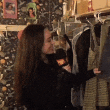 a woman is standing in front of a closet full of clothes