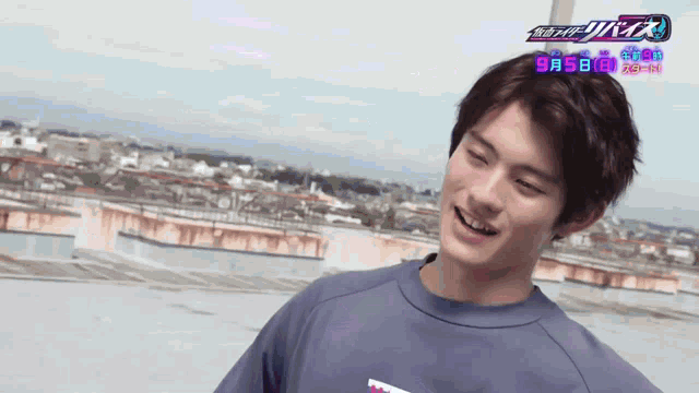 a young man wearing a blue shirt with the date 9 5 on it