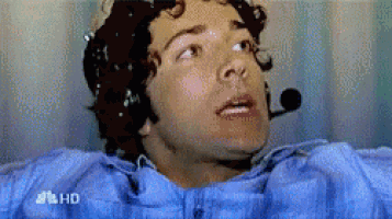 a man in a blue shirt is laying in a hospital bed with a microphone on his head and the word hd on the bottom left