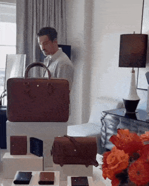 a man stands in front of a display of men 's bags