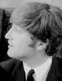 a black and white photo of a man in a suit and tie looking up .