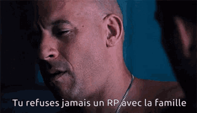 a man with a chain around his neck is talking to another man in french .