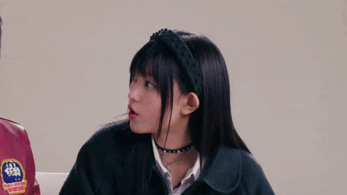 three girls are sitting next to each other with one wearing a jacket that has the letter l on it