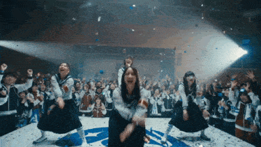 a group of girls are dancing on a stage with the letter a in the background