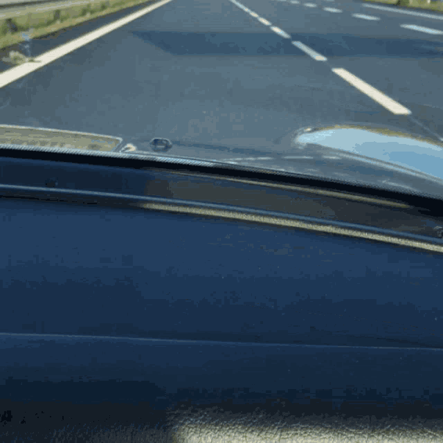 a view of a highway from inside a car with airbag visible