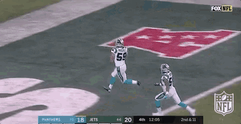 two football players are running on a field with a fox nfl logo in the background .