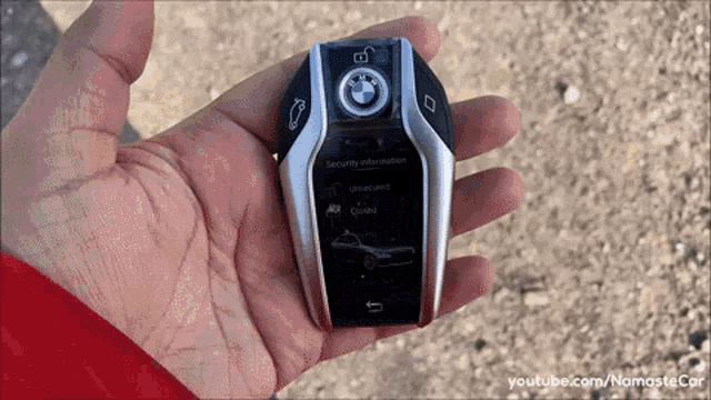 a person is holding a bmw remote control in their right hand